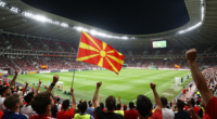 Kuzey Makedonya'da gece maçında taraftarların coşkuyla tezahürat yaptığı stadyum sahnesi.