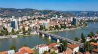 Makedonya'nın başkenti Skopje'nin havadan görünümü, taş köprü ve çevresindeki dağlar