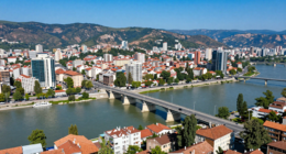 Makedonya'nın başkenti Skopje'nin havadan görünümü, taş köprü ve çevresindeki dağlar